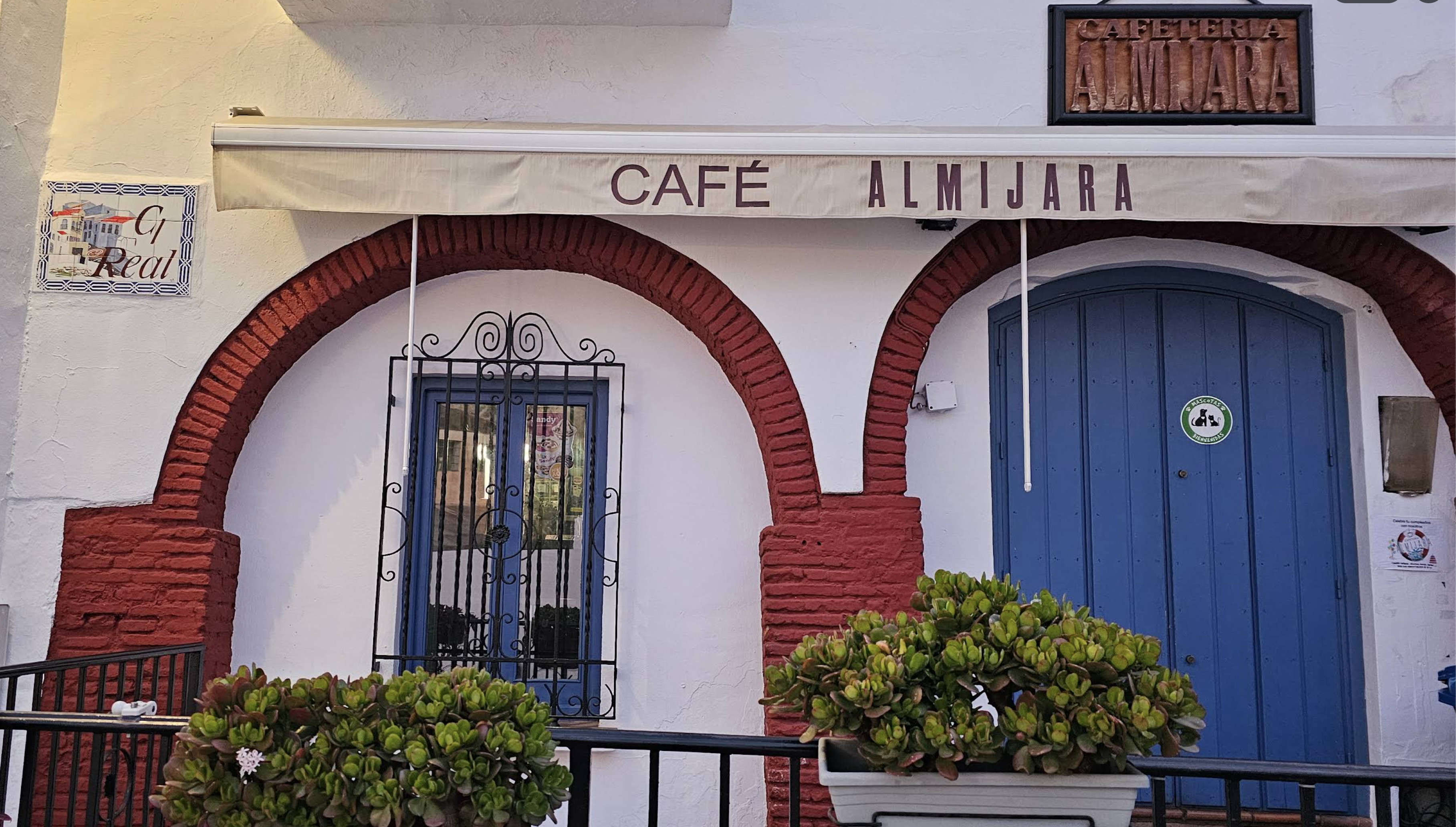Arched entrance and sign of Cafetería Almijara in Frigiliana